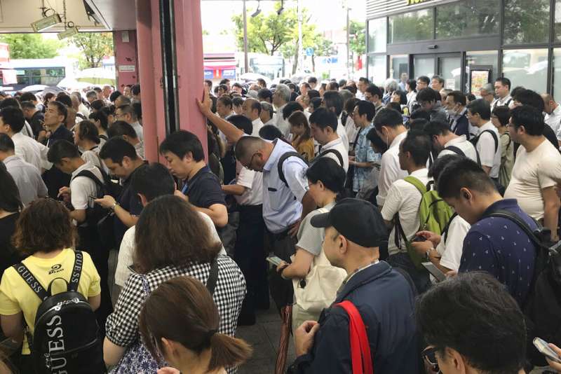 法西颱風直撲日本，許多電車都因而停駛延誤。圖為在橫濱車站等候的大批通勤旅客。（美聯社）