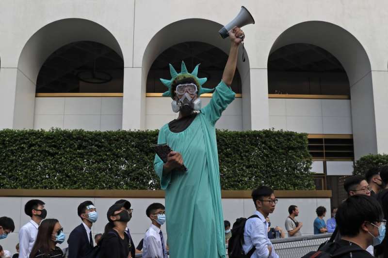 香港「反送中」抗議者扮成自由女神模樣，戴著防毒面具。（AP）