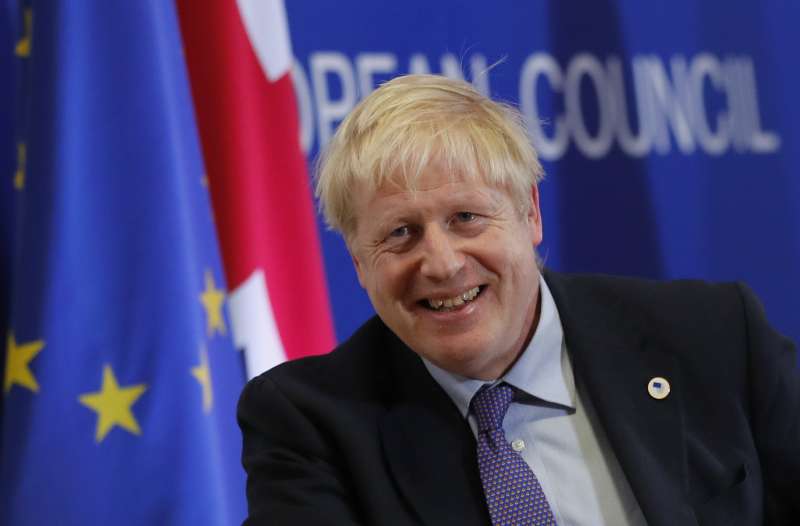 英國首相強森終於與歐盟達成新版退出協議,只待國會表決同意。圖為強森忍不住笑意。(AP) 英國首相強森終於與歐盟達成新版退出協議,只待國會表決同意。圖為強森忍不住笑意。(AP)