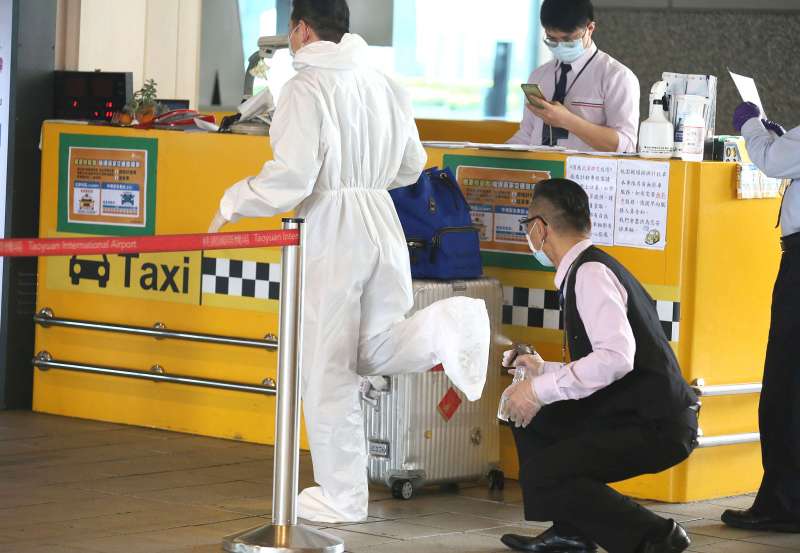 20200326-因武漢肺炎疫情管控出入境,桃園機場單日出入境人數已跌破萬人,圖為一位入境旅客準備搭乘機場防疫計程車前先清潔消毒.(柯承惠攝) 20200326-因武漢肺炎疫情管控出入境,桃園機場單日出入境人數已跌破萬人,圖為一位入境旅客準備搭乘機場防疫計程車前先清潔消毒.(柯承惠攝)
