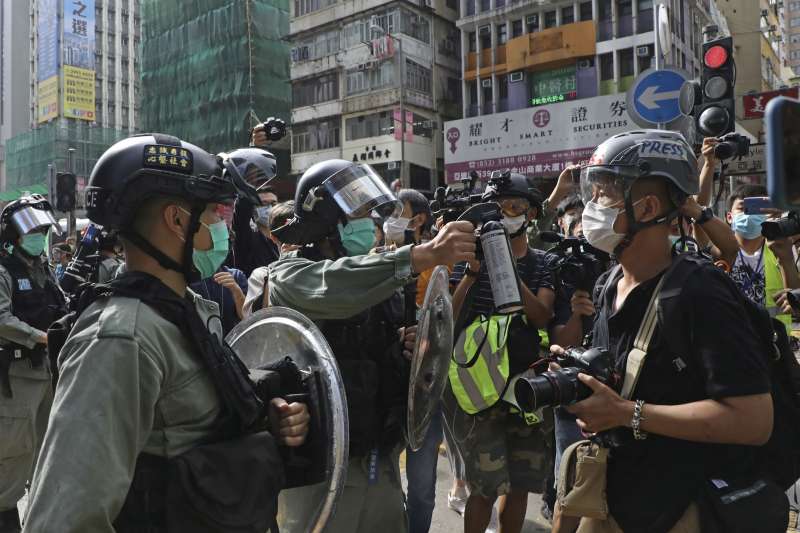 2020年4月，香港壟罩在新冠肺炎疫情中，警察與示威者都戴著口罩。（AP）