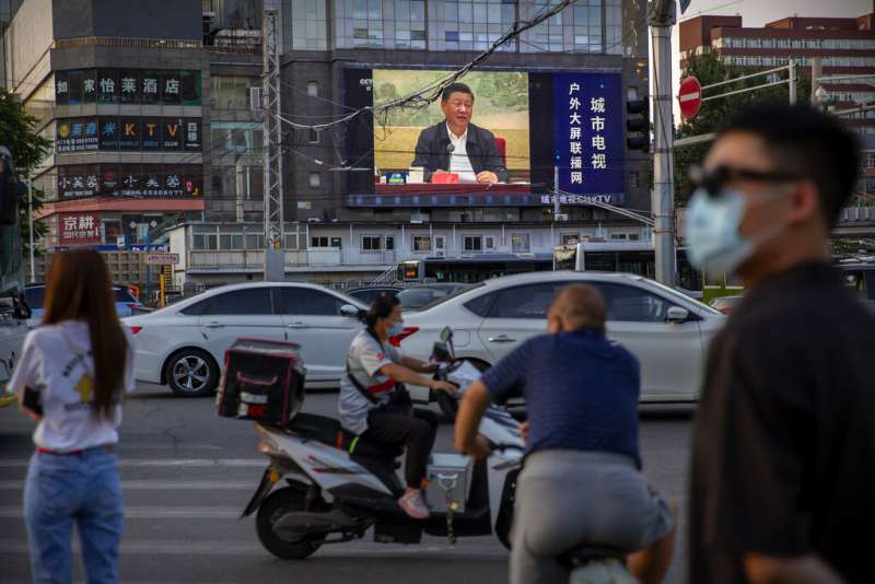 習近平發表談話的畫面出現在北京街頭。（美聯社）