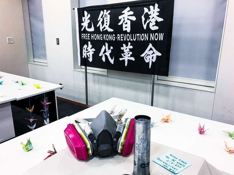 在東京都內舉辦的香港反送中一週年活動,現場展示香港抗爭者的防毒面具與催淚彈殼。(圖/作者提供) 在東京都內舉辦的香港反送中一週年活動,現場展示香港抗爭者的防毒面具與催淚彈殼。(圖/作者提供)