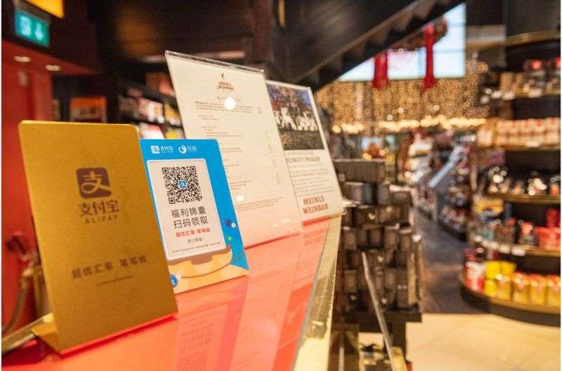 一家咖啡店收銀台前擺放著支持支付寶支付的牌子。(BBC News中文) 一家咖啡店收銀台前擺放著支持支付寶支付的牌子。(BBC News中文)