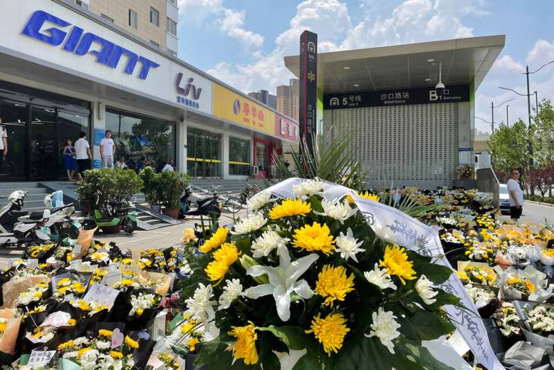 鄭州市民在地鐵五號線入口堆放鮮花,悼念罹難同胞。(美聯社) 鄭州市民在地鐵五號線入口堆放鮮花,悼念罹難同胞。(美聯社)