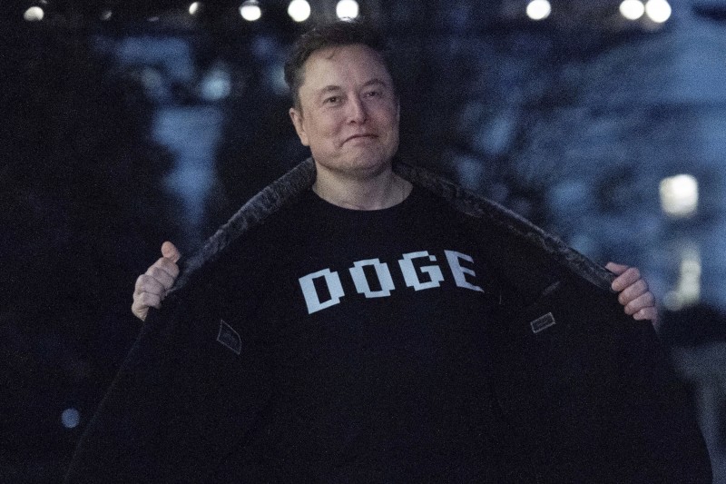 2025年3月9日、政府効率化省の略称「DOGE」とプリントされたTシャツを着るマスク氏。（AP通信）